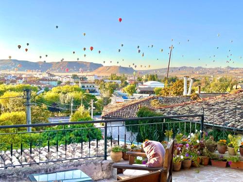 a person sitting on a bench watching hot air balloons at Sofa Hotel in Avanos