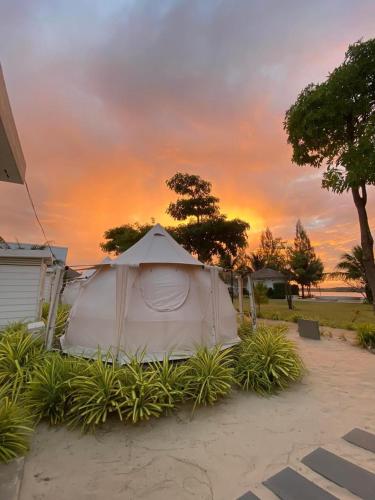 a white tent with a sunset in the background at Damboung Bungalow in Kampot