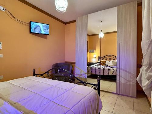 a bedroom with a bed and a tv on the wall at Agriturismo La Mora - Gemelli in Assisi