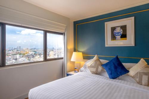 a bedroom with a large bed and a window at Grand China Bangkok in Bangkok