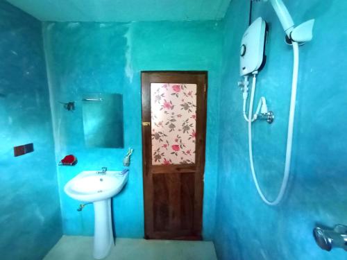 a blue bathroom with a sink and a shower at vihanga homestay in Mirissa