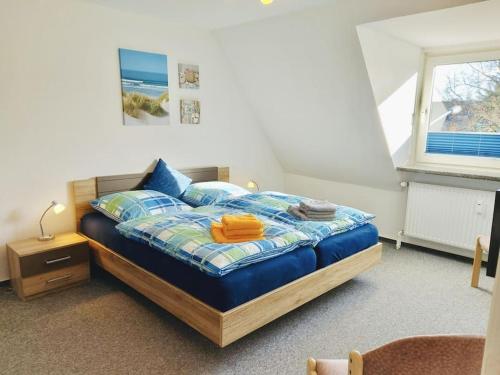 a bedroom with a bed with a blue comforter and a window at Wolke 7 von OstseeAhoi in Lübeck