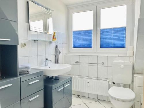 a white bathroom with a toilet and a sink at Wolke 7 von OstseeAhoi in Lübeck