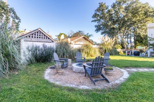 three chairs sitting around a fire pit in a yard at OBX Beach Gnome in Kill Devil Hills