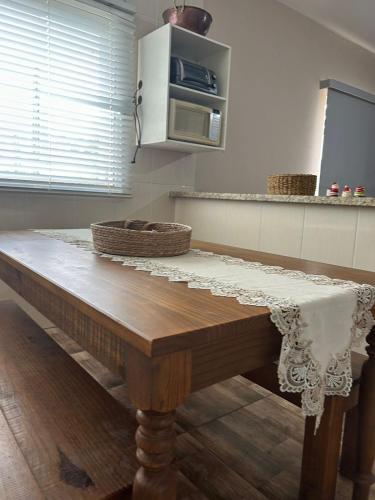 a table in a kitchen with a microwave at Casa Por do Sol in Espirito Santo Do Pinhal