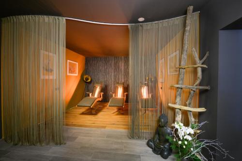 a living room with two chairs and a tree at Landhotel Anna in Sankt Martin am Tennengebirge