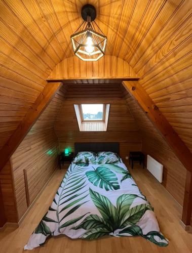 - une chambre avec un lit dans un grenier en bois dans l'établissement Bulle, à Saint-Martin-des-Champs