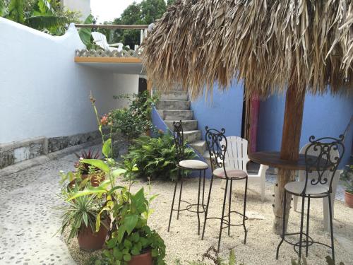 a patio with chairs and a table and some plants at Amaranto Bed and Breakfast in Cozumel