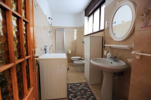 コーレレにあるCasa Valentinaの洗面台、トイレ、鏡のあるバスルーム