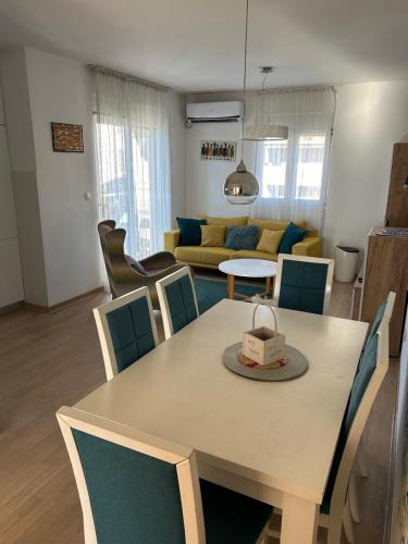 a dining room and living room with a table and chairs at Ana’s 2 bedrooms lovely flat in Podgorica