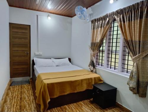 a bedroom with a bed and a window at Verdant Hillock in Wayanad