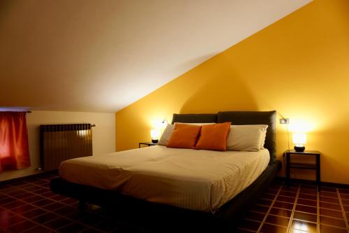 a bedroom with a bed with two orange pillows on it at Attic House Mountain Lake Iseo Hospitality in Bossico