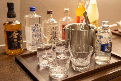 a tray with glasses and bottles of alcohol on a counter at 皆玉邸 恵 in Sakaiminato