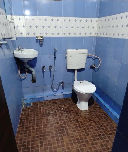 a blue bathroom with a toilet and a sink at Verdant Hillock in Wayanad