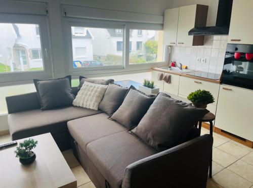 un salon avec un canapé et une cuisine dans l'établissement Bulle, à Saint-Martin-des-Champs