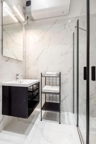a white bathroom with a sink and a shower at A Golden Star Modern Luxury Apartments and Rooms Budapest in Budapest