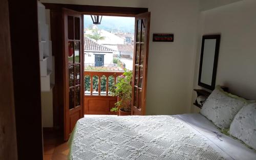 a bedroom with a bed and a view of a balcony at Apartamento Cemandy in Villa de Leyva