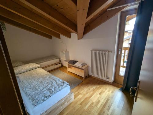 a small bedroom with a bed and a window at Casa del ruscello in Mezzana