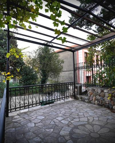 a patio with a fence and a stone walkway at Αρχοντικό Βιζυηνού in Xanthi