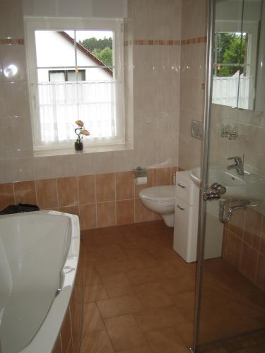 a bathroom with a tub and a sink and a toilet at Haus Schwielochsee in Schwielochsee