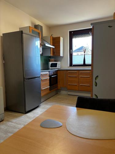 a kitchen with a stainless steel refrigerator and a table at Ski Vital Apartments in Sankt Michael im Lungau