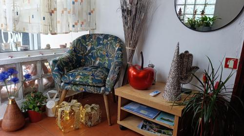 a living room with a chair and a table at Orion Guesthouse Telhado in Fundão