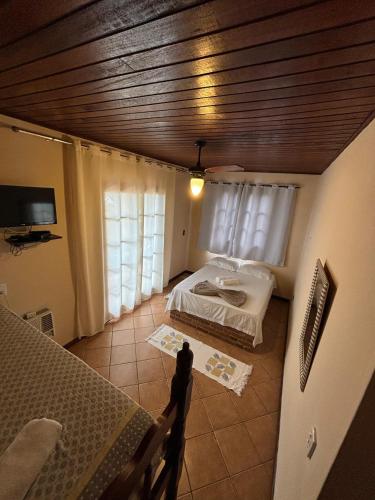 a bedroom with a bed in a room with a ceiling at Pousada Tony Montana in Praia de Araçatiba