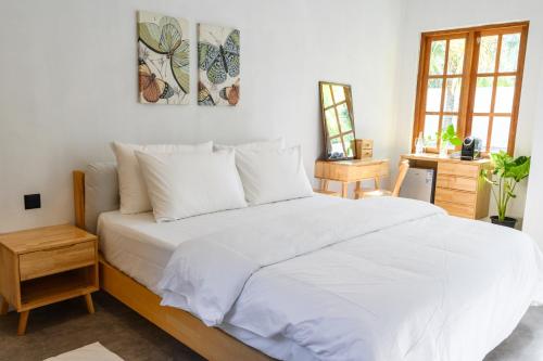 a bedroom with a large white bed with white sheets at Kondey Villas in Kondey