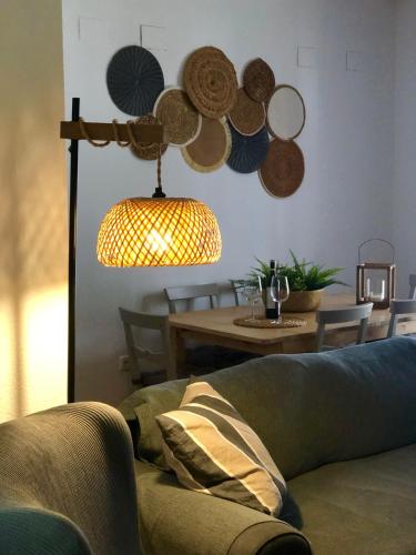 a living room with a couch and a table with a lamp at Alojamiento La Fuente in Fuenteheridos