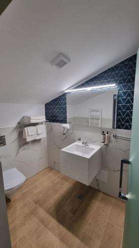a bathroom with a white sink and a toilet at Heritage Boutique in Caracal