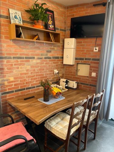 - une table en bois dans une chambre dotée d'un mur en briques dans l'établissement Rambouillet, à Rambouillet