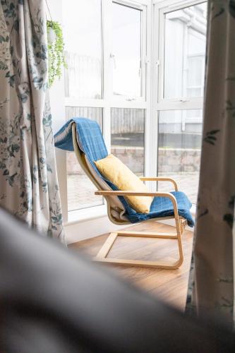 a chair in a room with a window at Beach Park House in Downings