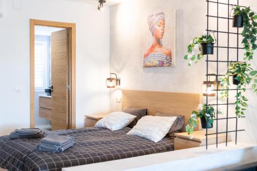 ein Schlafzimmer mit einem Bett und einem Gemälde an der Wand in der Unterkunft Estudio Glamuroso cerca de la playa en Mijas Costa in Málaga