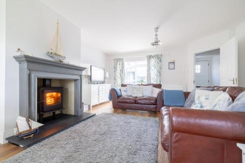 a living room with a couch and a fireplace at Beach Park House in Downings