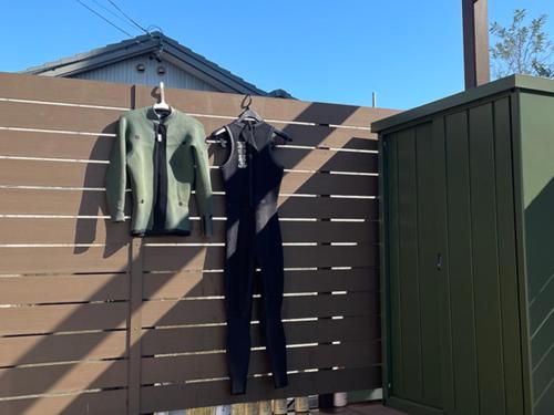 a wall with two shirts and pants hanging on it at Glam Pool Terrace Shizunami in Makinohara