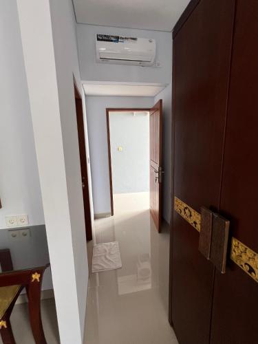 a hallway with a door leading to a room at Mandhasativa Homestay in Singaraja
