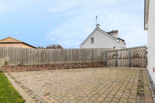 a wooden fence in front of a white house at Beach Park House in Downings