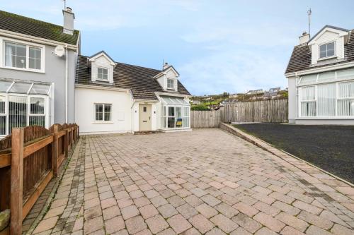 a brick driveway in front of a white house at Beach Park House in Downings