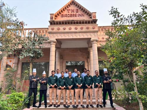 a group of men in uniform standing in front of a building at The Birder's Inn in Bharatpur