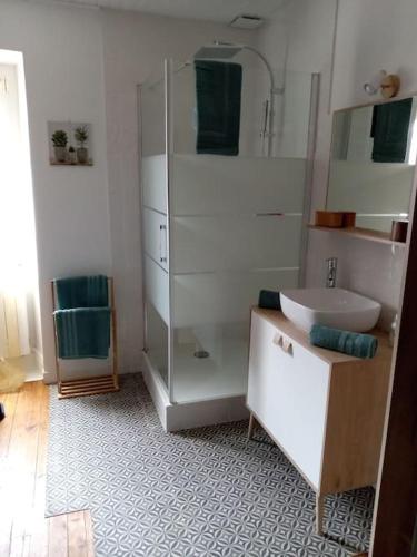 une salle de bain blanche avec une douche et un lavabo dans l'établissement Les fontaines, à Saint-Vincent
