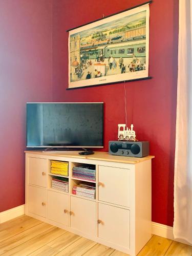 a living room with a television on a white cabinet at Bahnhof Frauenstein Wartehalle in Frauenstein