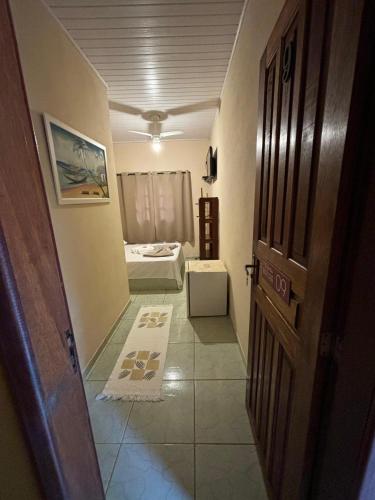 a hallway with a room with a bed and a door at Pousada Tony Montana in Praia de Araçatiba
