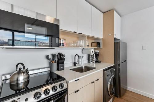 a kitchen with a sink and a stove top oven at DT Studio Gym Pool Table 8th Floor Parking in Salt Lake City