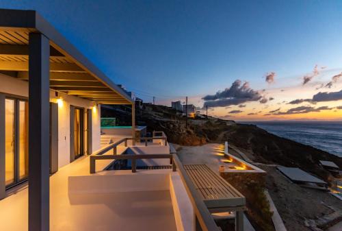 a house with a balcony with a view of the ocean at Phos Villas Tinos in Agios Romanos