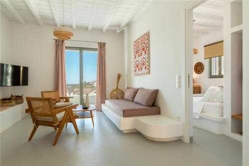 a living room with a couch and a bed at Phos Villas Tinos in Agios Romanos