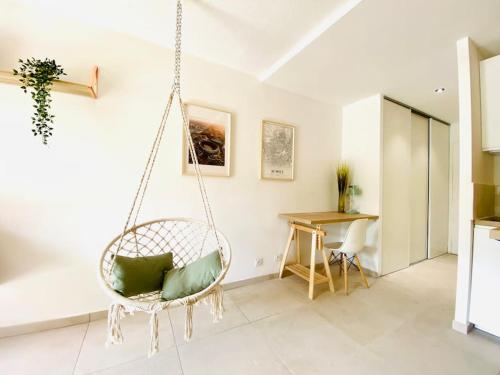 un fauteuil roulant dans un salon avec une table dans l'établissement Studio Boho Clim Parking terrasse, à Nîmes