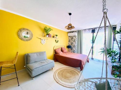 Cette chambre dispose d'un lit pliant et d'une chaise. dans l'établissement Studio Boho Clim Parking terrasse, à Nîmes