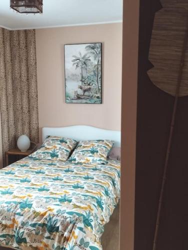 une chambre avec un lit et un tableau au mur dans l'établissement La Desirade, à Le Coudray-Macouard