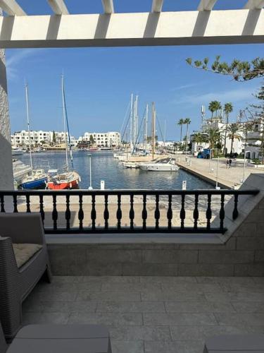 a balcony with a view of a harbor with boats at Appartement luxe avec vue sur le port de Kantaoui in Port El Kantaoui