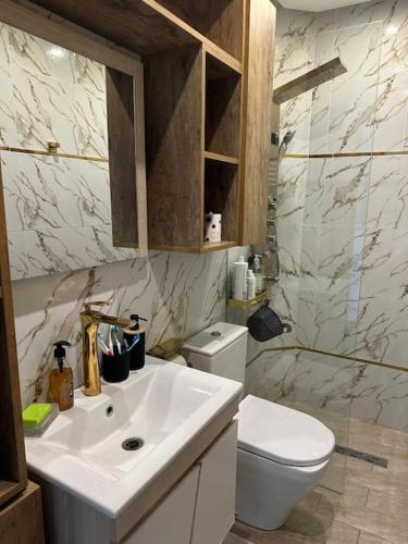 a bathroom with a white sink and a toilet at Appartement luxe avec vue sur le port de Kantaoui in Port El Kantaoui